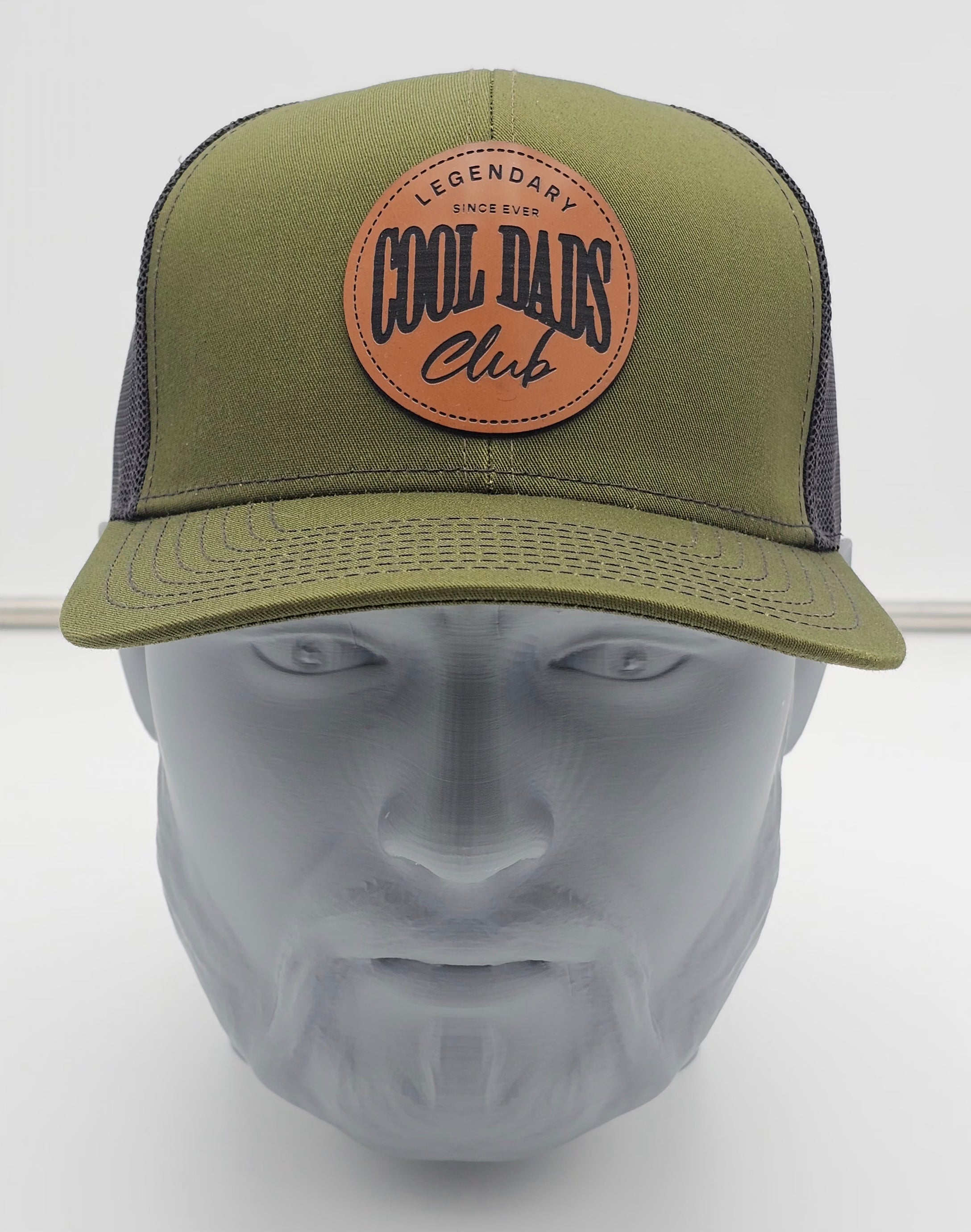 Green cap with leather patch on a mannequin head against a white background