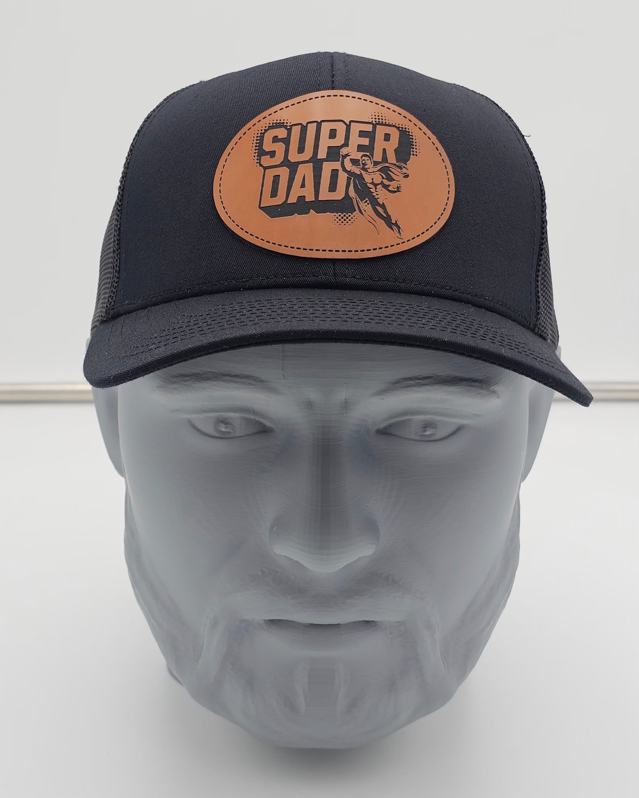 Black cap with 'Super Dad' leather patch on a mannequin head against a white background
